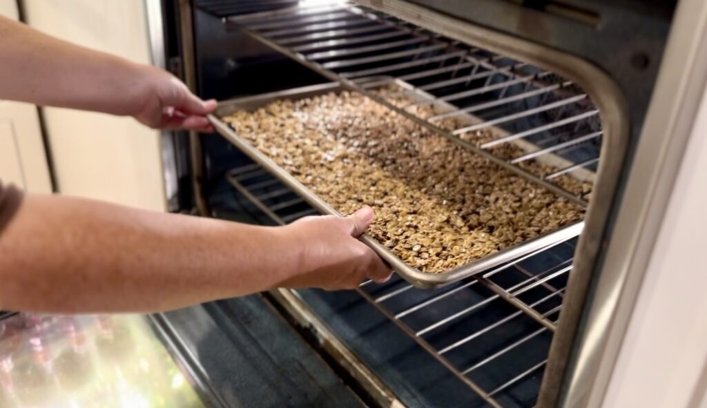 women puts granola into the kitchen aid wall oven