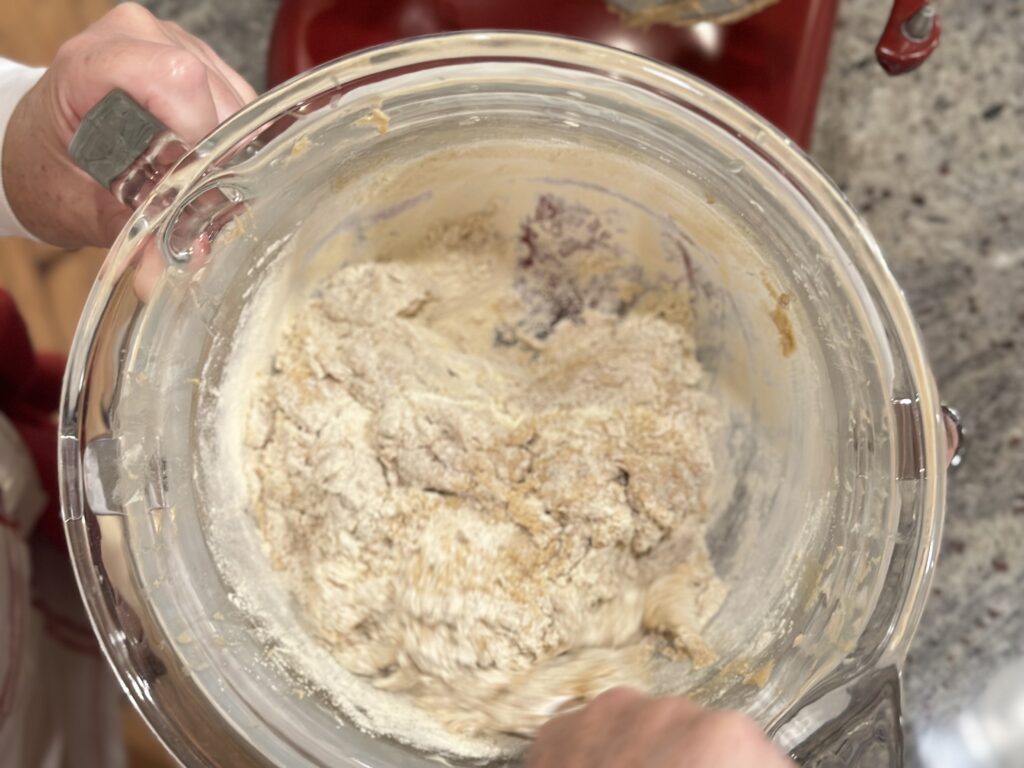 making cookies adding sugar to butter in a red KitchenAid stand mixer with a glass bowl ingredients just combined