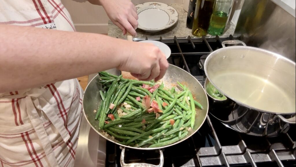 Green Beans with Bacon onions are cooked add green beans add in bacon