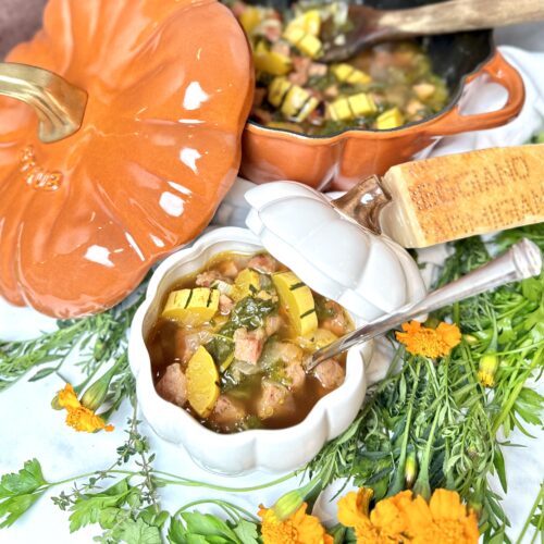Harvest Soup Full View in a Staub Cast Iron Dutch Oven in a Pumpkin Shape with herbs and marigolds served in a white pumpkin bowl