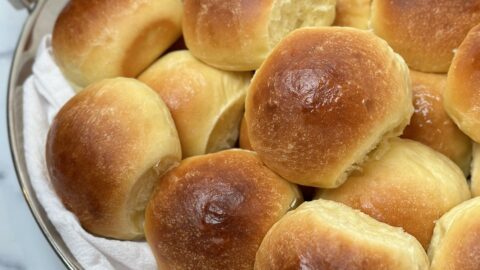The Perfect Dinner Roll close up side view on a chrome tray with apricot jam and butter