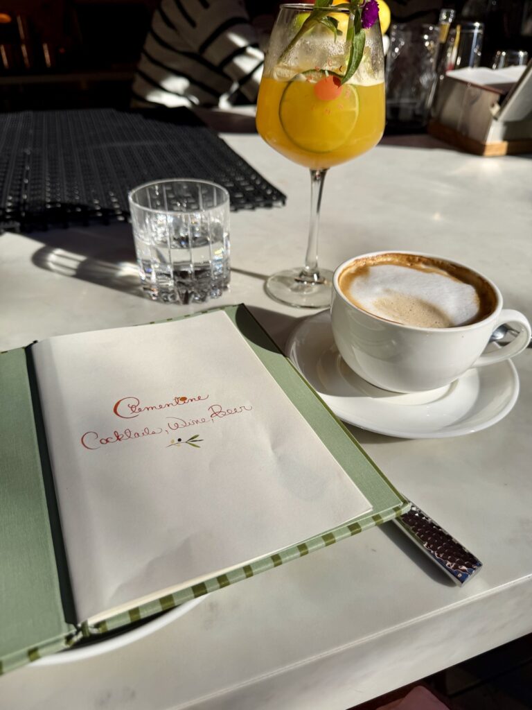 Clementine Yountville bar seating latte in a white cup and saucer, Clementine Paloma in a stemmed glass and the Clementine cocktail wine menu