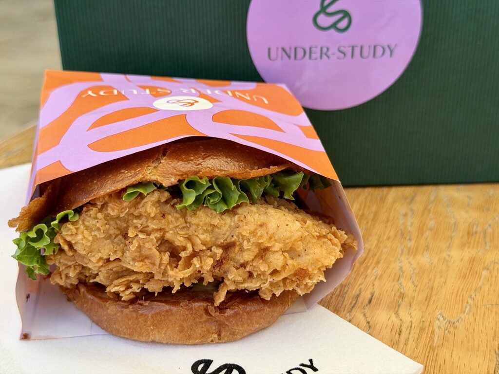 A picture of a fried chicken sandwich with pickled green tomatoes, and Pedro Pepper aïoli from Under-Study in Saint Helena.