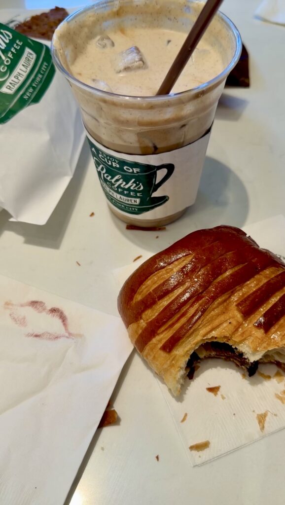 Picture of Ralph coffee iced latte pan shot a lot with a bite out of it Lysik lips on a paper napkin