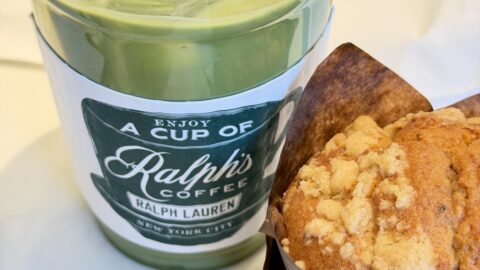 A picture of an iced latte in a Ralph, coffee, coffee collar, and a blueberry muffin