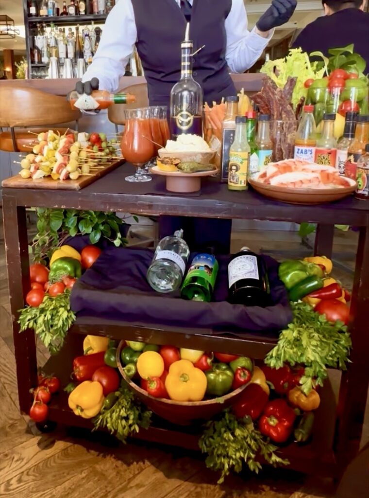 A picture of the bloody Mary cart at Baltaire, making a bloody Mary adding Tabasco
