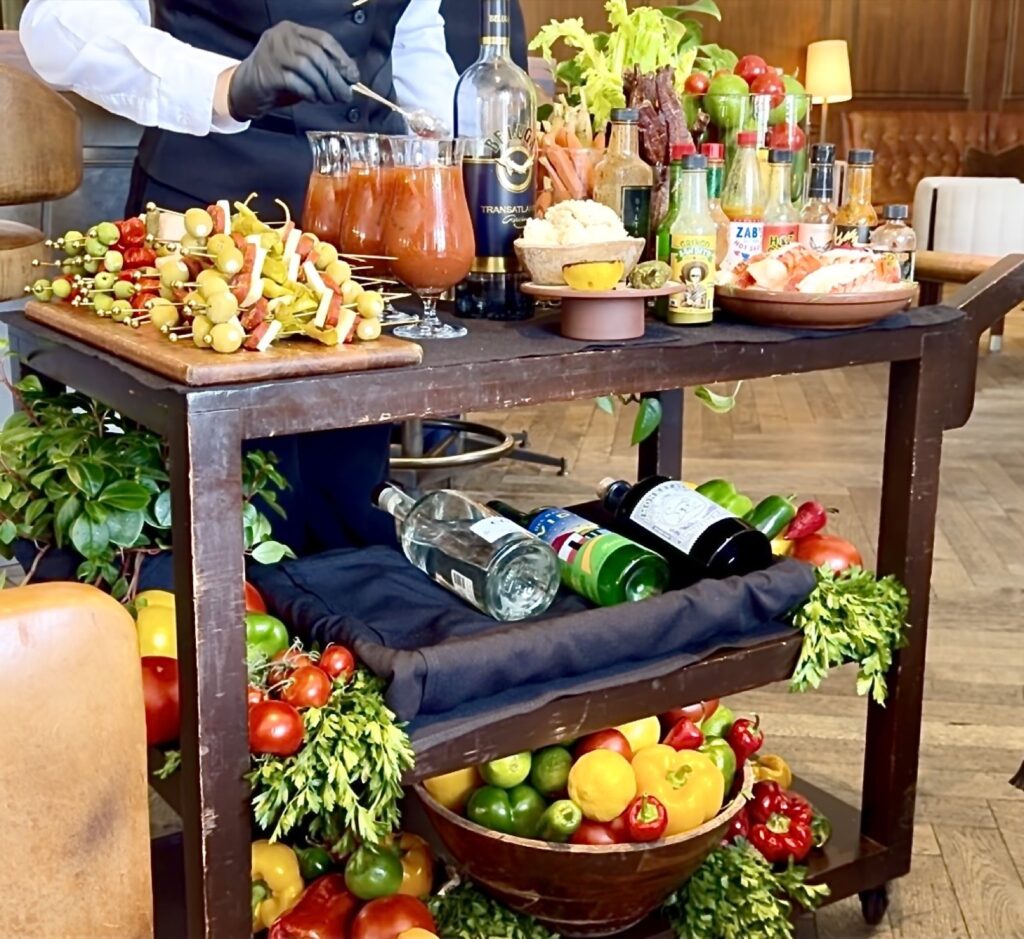 A picture of the bloody Mary cart at Baltaire making a bloody Mary, adding horseradish