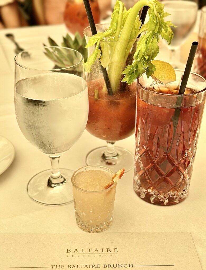 Brunch at Baltaire a picture of multiple beverages a glass of water, partially drinking, bloody Mary and iced tea and a frozen Paloma