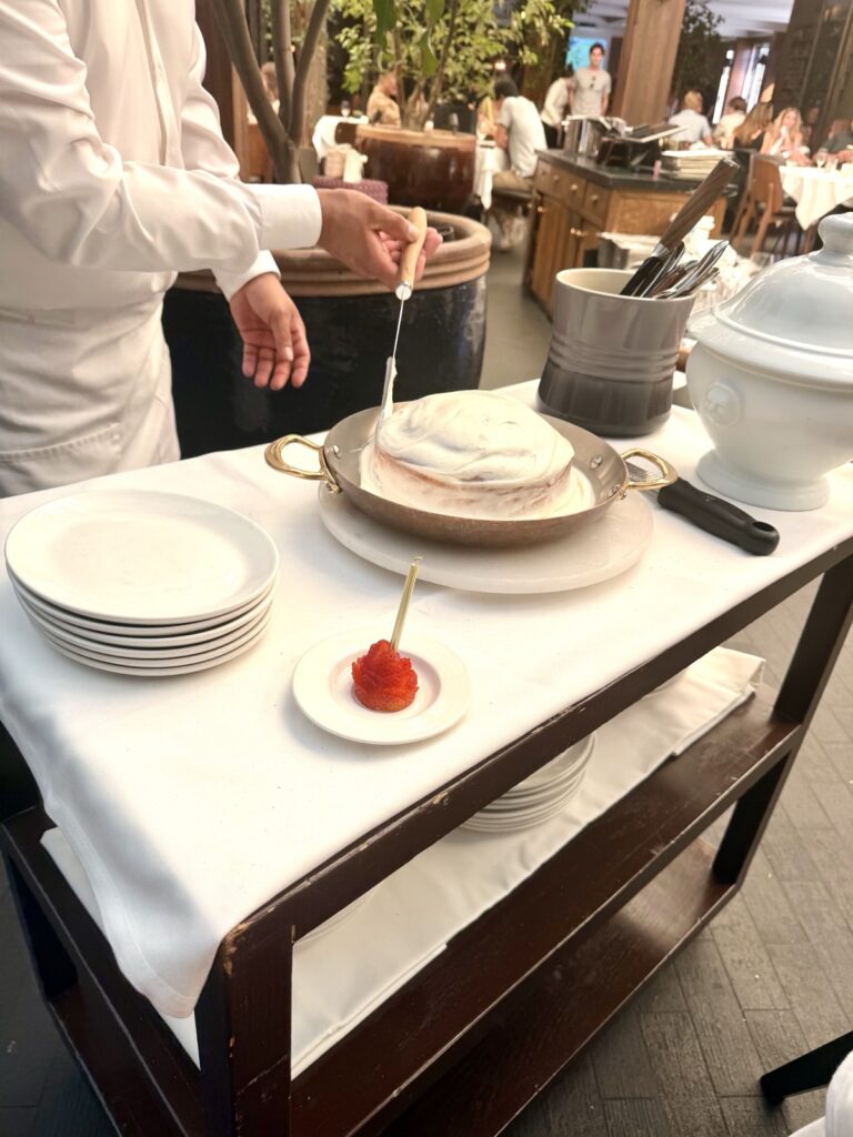 Brunch at Baltaire, frosting a large table side cinnamon roll