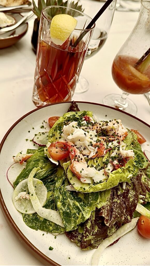 Brunch at Baltaire: a picture of the lobster salad on a white plate with a brown rib and a iced tea with a lemon wedge behind it