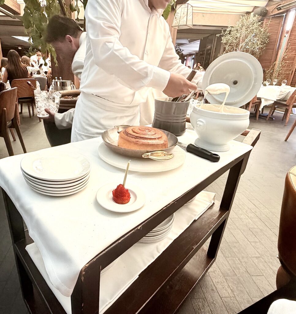 Brunch at Baltaire table side, extra large cinnamon roll, scooping out the frosting