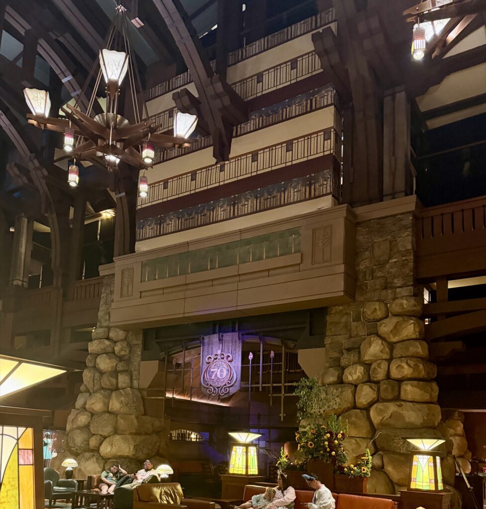 A picture of the lobby of the grand Californian Hotel showing the fireplace hearth decorated with a 70th anniversary banner.