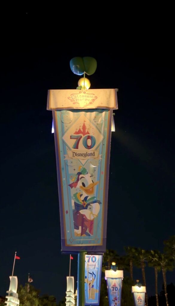 This is a picture of a Disneyland 70th anniversary celebration banner featuring Daisy. It is located in the corridor between the Disneyland gate entry and the Disney California gate entry.