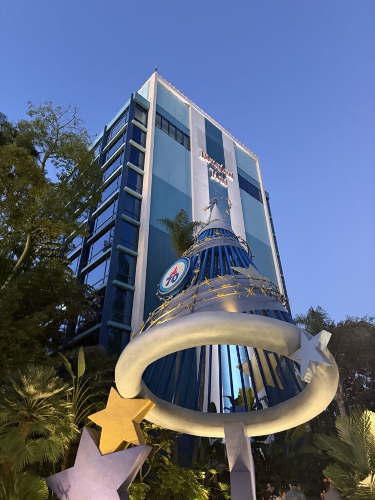 A picture of Disneyland 70th celebration decoration on the Mickey Mouse Fantasia hat in front of the Disneyland hotel.