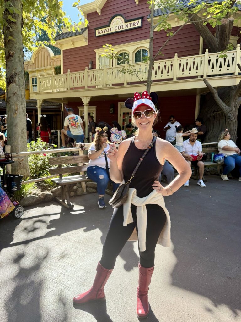 A picture of Rachael from a life full of living at Disneyland holding a 70th anniversary themed treat