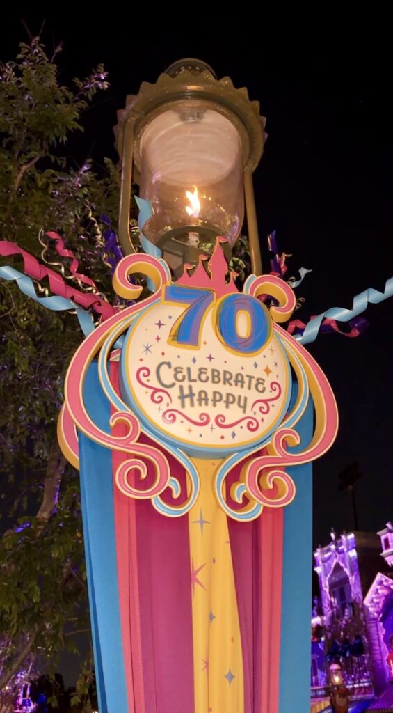 This is a picture of Disneyland's 70th celebrate happy anniversary party decoration under a beautiful glass lamp when you first enter the park