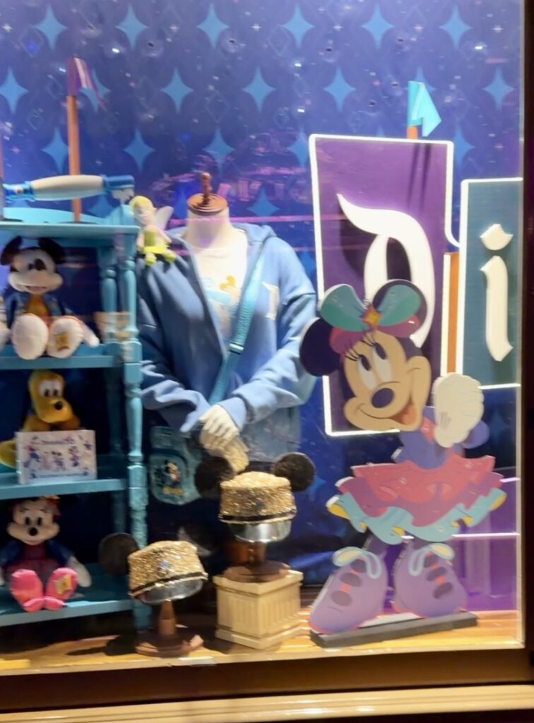 This is a picture of a merchandise window at Disneyland Emporium on Main Street featuring Disneyland 70th merchandise