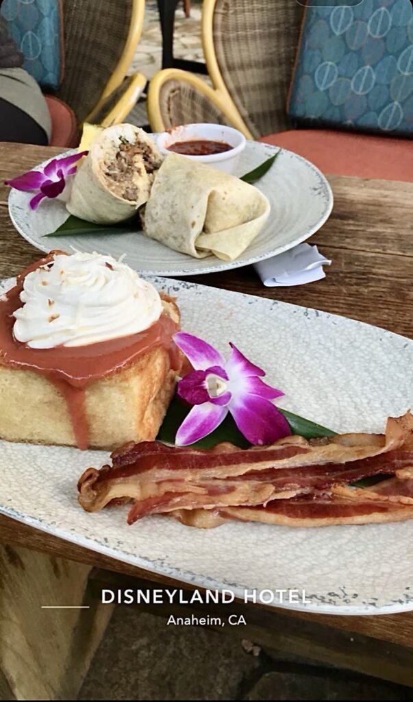 A picture of stuffed French toast and a side of bacon with a picture of the Loco moco burrito in the background both items are from Tangaroa Terrace at the Disneyland hotel.