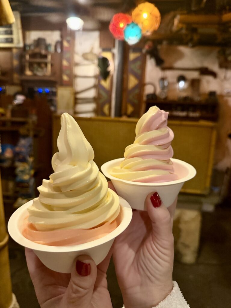 A picture of two Dole whip bowls with two different flavors, one as a swirl and the other with one flavor layered onto the other. Dole whips are from Tropical Hideaway at Disneyland.