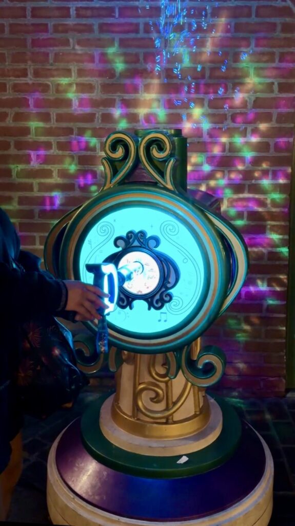 A picture of Disneyland's 70th Anniversary Key Experience in action. It shows the key lighting up with bubbles coming out. This key was in the French Quarter of Disneyland.