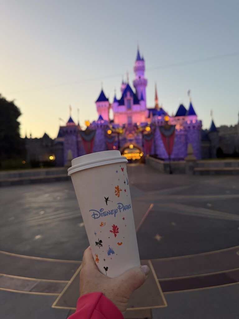 A picture of a Disney Starbucks cup in front of Sleeping Beauty's Castle at Disneyland.