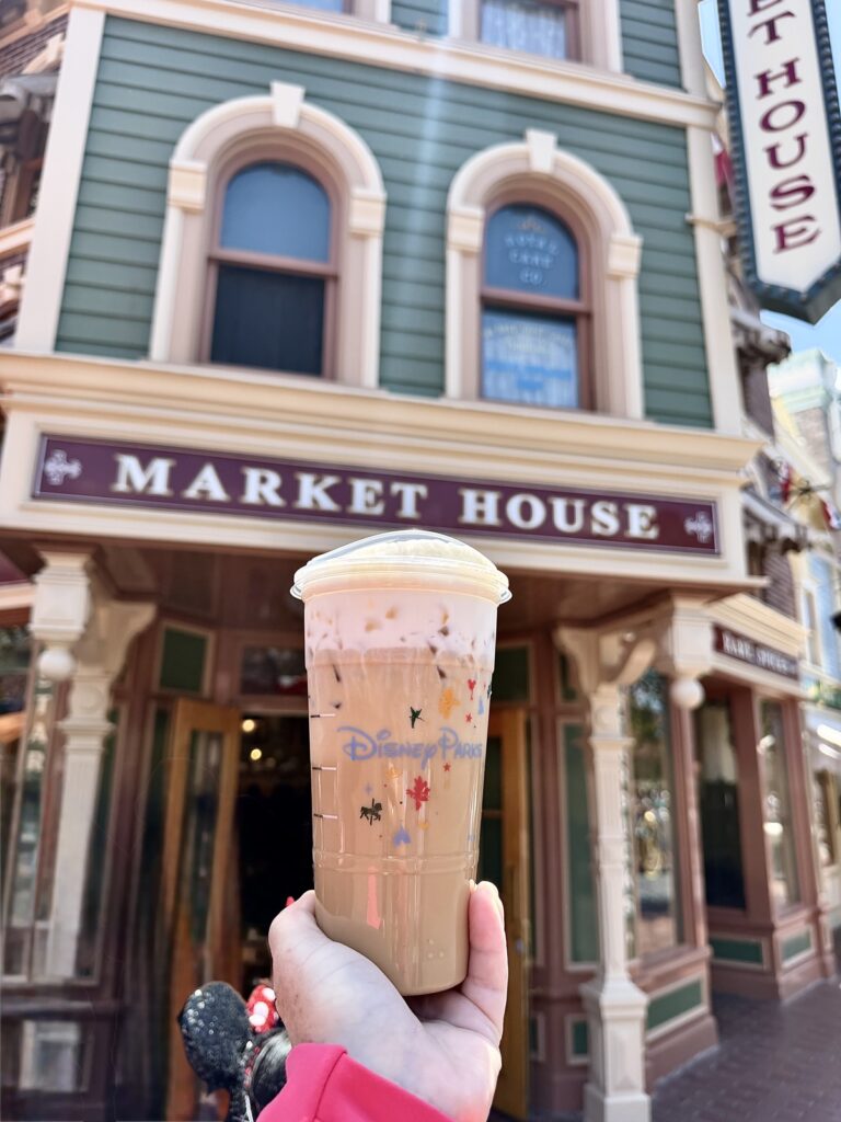 A picture of an iced latte in a Disney Starbucks cup from Starbucks in Disneyland on Main Street at the Market House location.